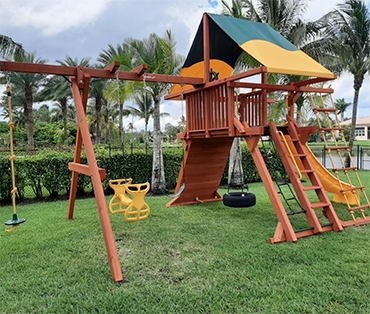 Woodplay angle base with tire swing, rope ladder,climbing wall installed in Davie, Florida. 